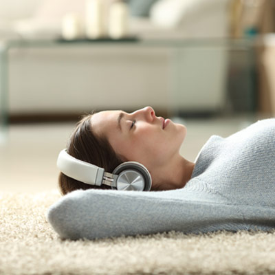woman enjoying floor time on carpet flooring with headphones