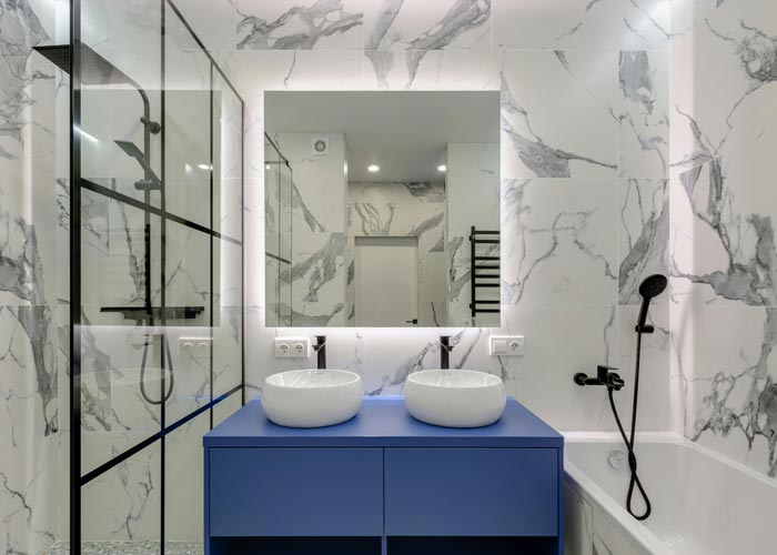 bathroom with blue vanity and mirror lighting