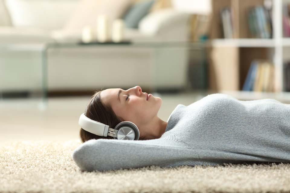 woman enjoying floor time on carpet with headphone